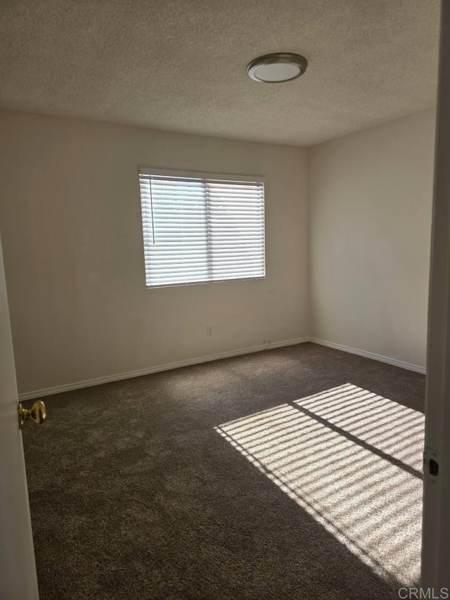 carpeted spare room featuring a textured ceiling