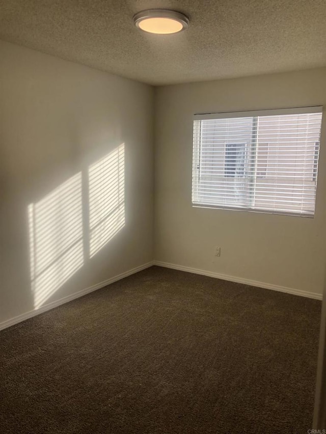 carpeted spare room featuring a textured ceiling