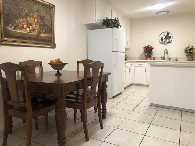 dining room featuring sink and light tile patterned floors