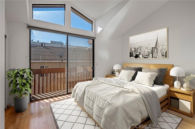 bedroom with vaulted ceiling and light hardwood / wood-style flooring