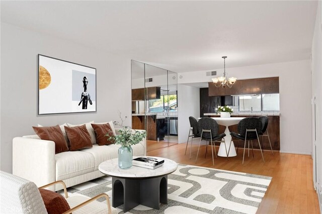 living room with a chandelier and light hardwood / wood-style floors