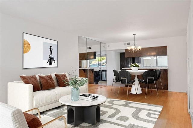 living room with a chandelier and light wood-type flooring