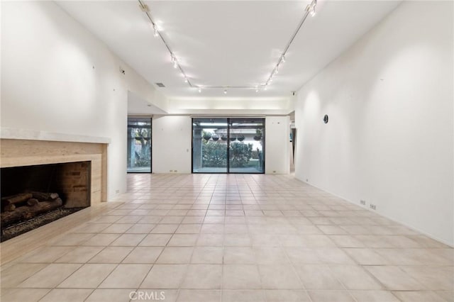 unfurnished living room featuring light tile patterned floors and a high end fireplace