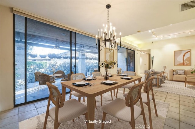 dining area featuring an inviting chandelier, light tile patterned floors, and expansive windows