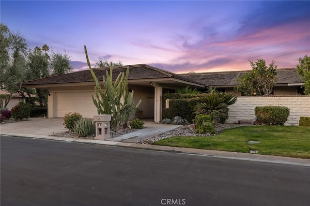 view of front of property with a garage and a lawn