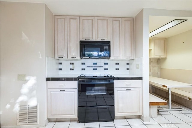 kitchen featuring tile counters, light tile patterned floors, backsplash, and electric range oven