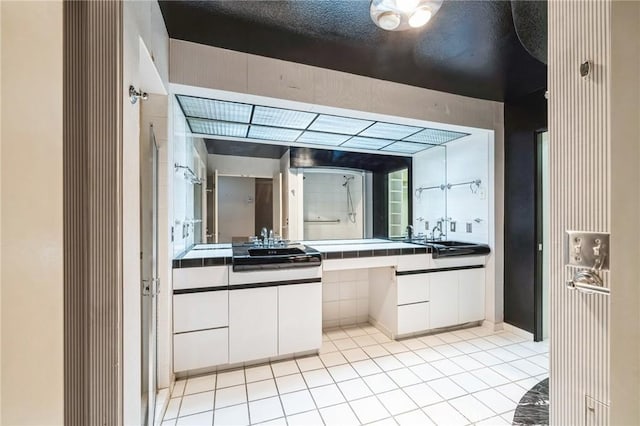 bathroom with tile patterned floors, walk in shower, and vanity