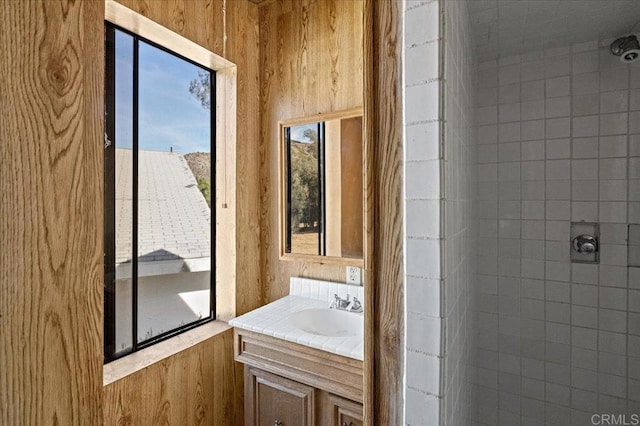 bathroom featuring tiled shower and vanity