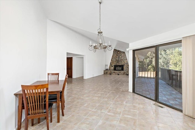 dining space featuring light tile patterned floors, visible vents, a chandelier, a fireplace, and high vaulted ceiling