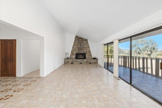 unfurnished living room with high vaulted ceiling, a fireplace, and visible vents