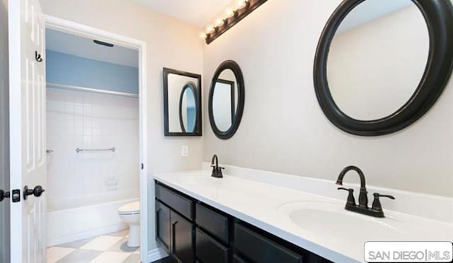 full bathroom with toilet, vanity, and tiled shower / bath