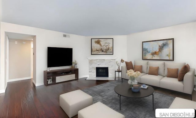 living room with a fireplace and dark wood-type flooring