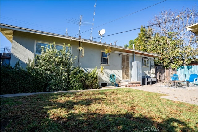 rear view of property with a yard and a patio