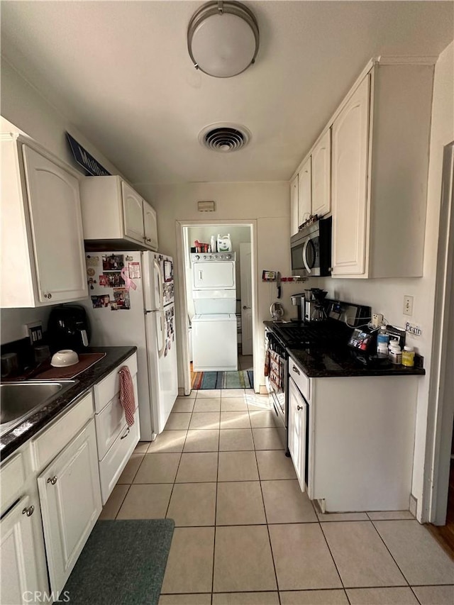 kitchen with light tile patterned floors, appliances with stainless steel finishes, white cabinets, and sink