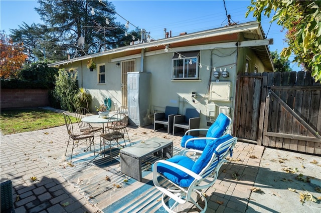 rear view of property with an outdoor living space and a patio area