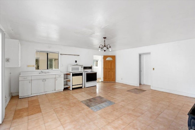 kitchen with white appliances, white cabinets, a chandelier, and hanging light fixtures