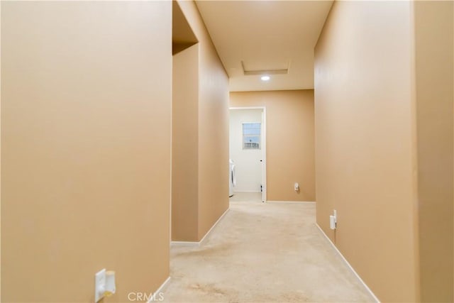 hall featuring washer / dryer and light carpet