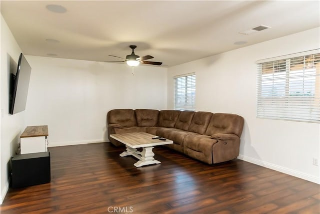 living room featuring ceiling fan and dark wood-type flooring