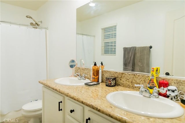 bathroom with toilet, vanity, and a shower with shower curtain