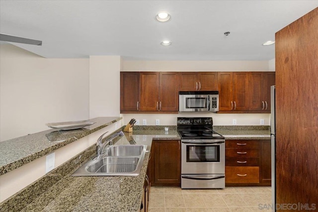 kitchen with appliances with stainless steel finishes, sink, and stone counters