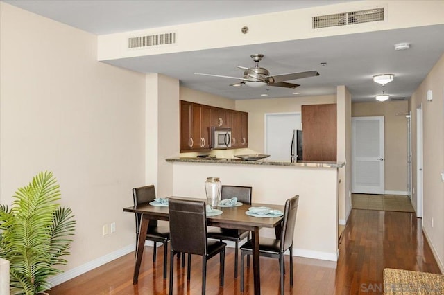 dining area featuring ceiling fan and dark hardwood / wood-style floors