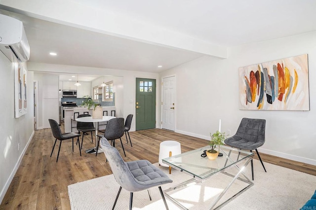 living room featuring wood-type flooring, beam ceiling, and a wall mounted AC