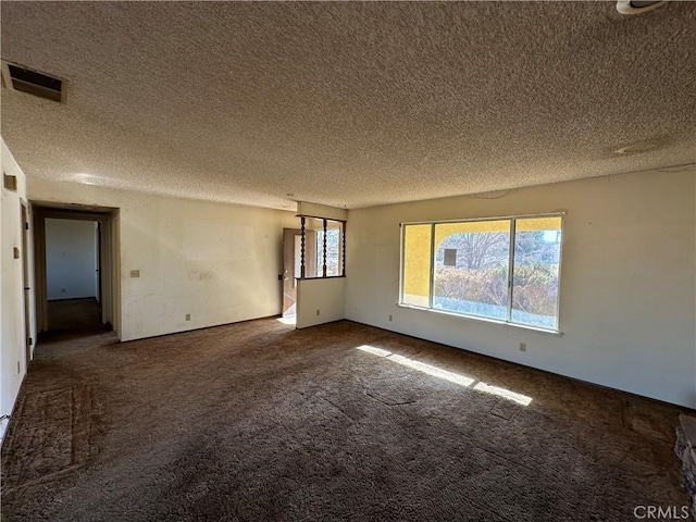 carpeted spare room featuring a textured ceiling