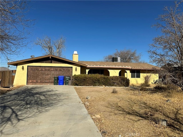 ranch-style house with a garage and central AC unit