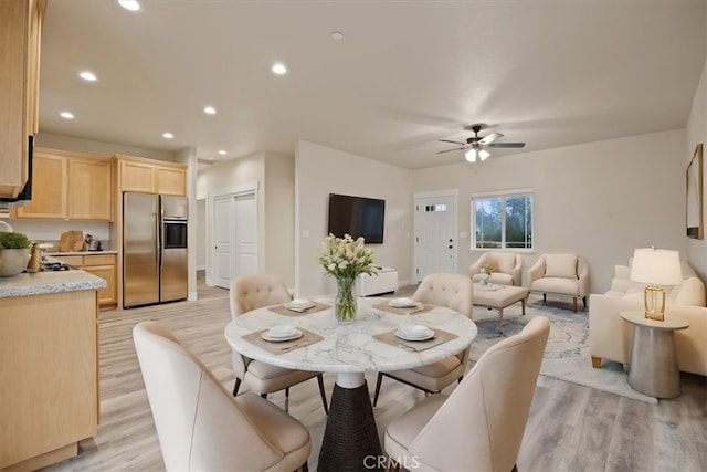 dining room with ceiling fan and light wood-type flooring