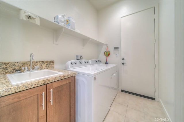 laundry area featuring light tile patterned floors, sink, and separate washer and dryer