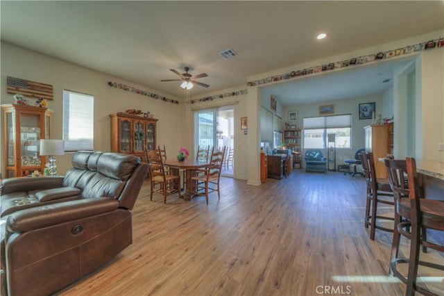 living room with light wood-type flooring and ceiling fan