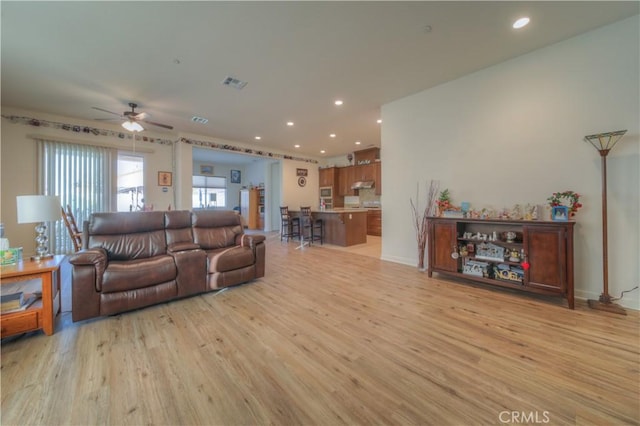 living room featuring ceiling fan and light wood-type flooring