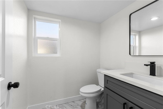 bathroom featuring toilet, a healthy amount of sunlight, and vanity