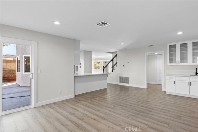 unfurnished living room with light hardwood / wood-style floors and sink