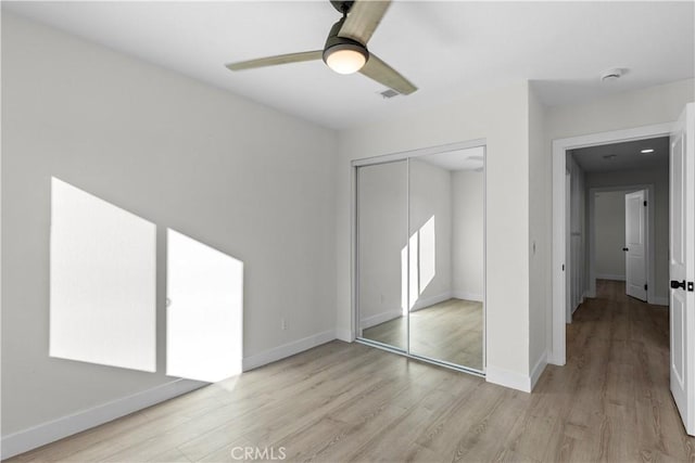 unfurnished bedroom featuring light wood-type flooring, a closet, and ceiling fan