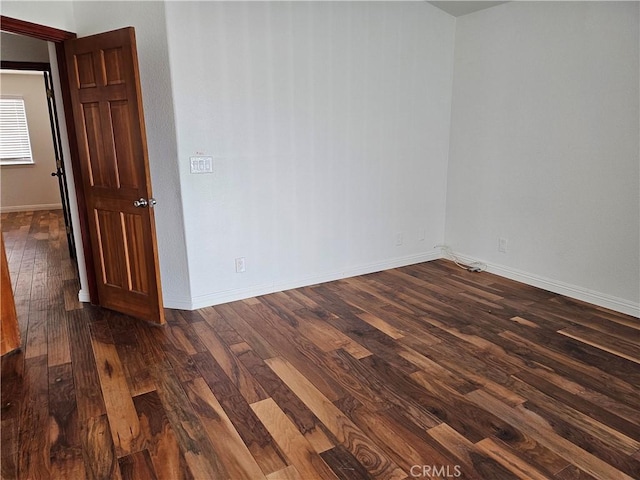 spare room with dark wood-type flooring