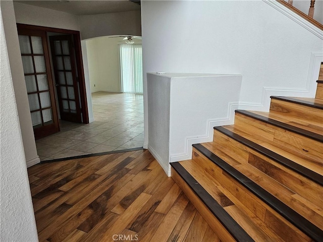 stairs featuring ceiling fan and tile patterned flooring