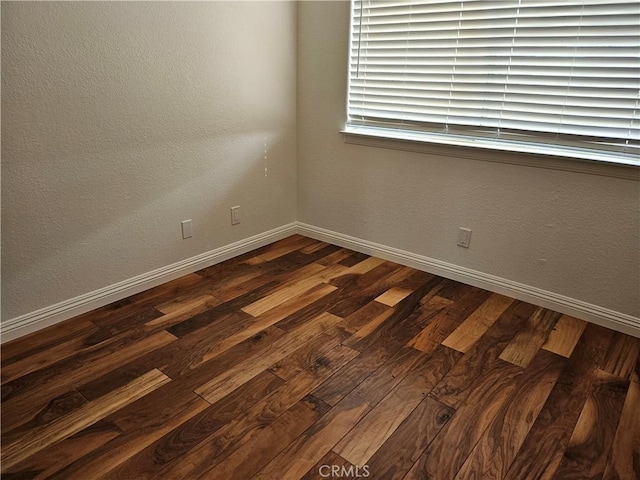 spare room featuring dark wood-type flooring