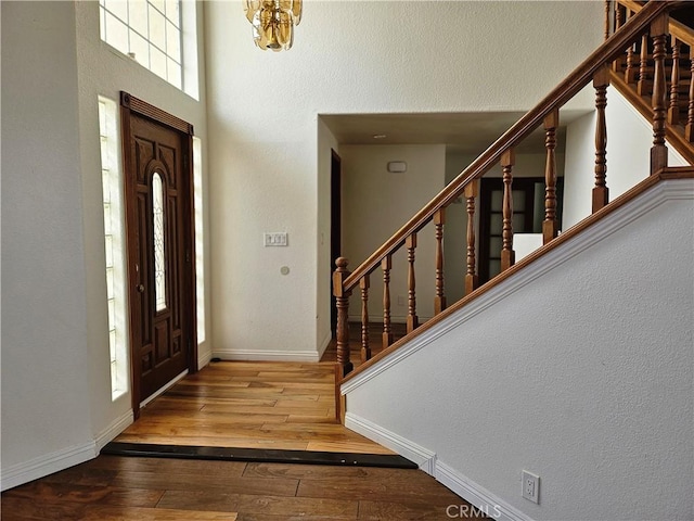 entrance foyer with wood-type flooring and a notable chandelier