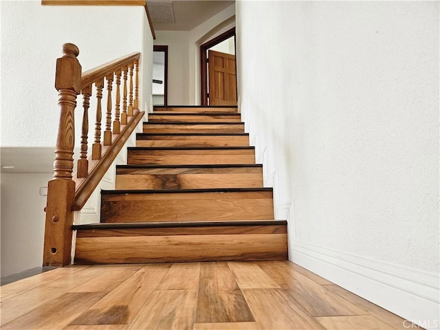 stairway with hardwood / wood-style floors