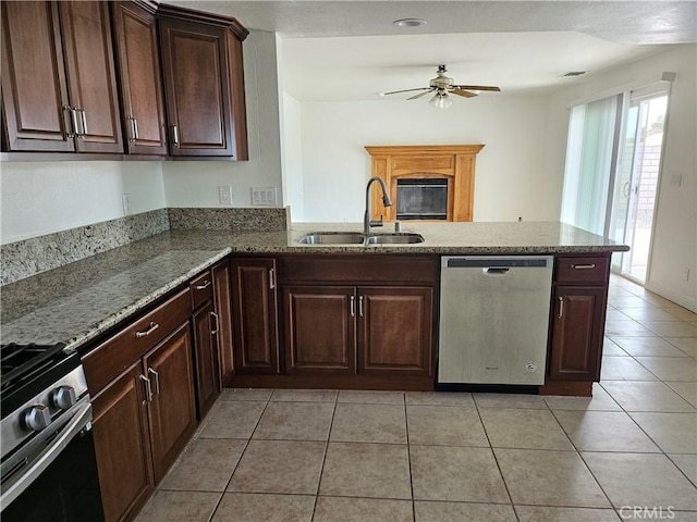 kitchen featuring kitchen peninsula, ceiling fan, stainless steel appliances, light tile patterned flooring, and sink