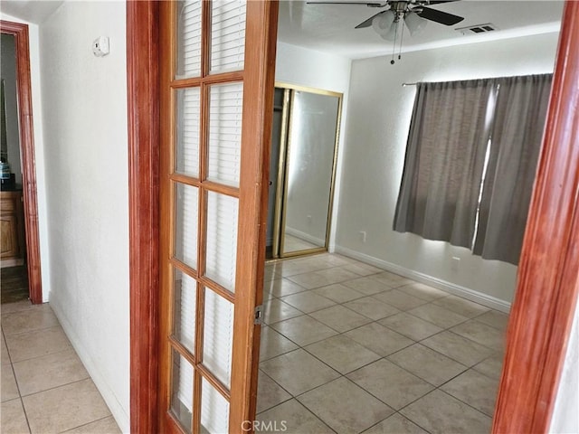 interior space with ceiling fan and tile patterned flooring