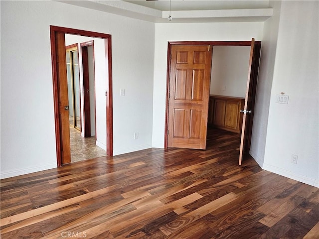 empty room with dark hardwood / wood-style flooring