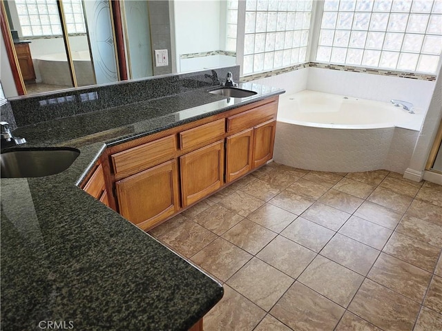 bathroom featuring tile patterned floors, tiled tub, and vanity