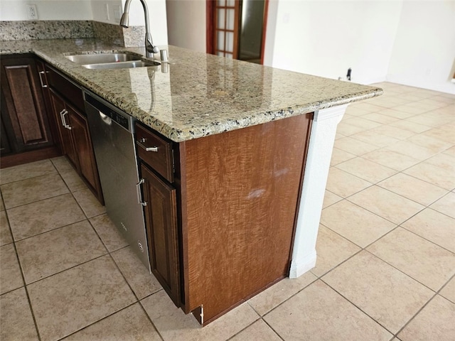 kitchen with light tile patterned floors, kitchen peninsula, light stone countertops, stainless steel dishwasher, and sink