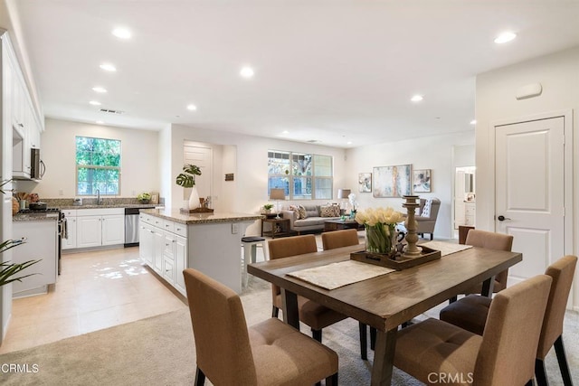 dining space with light carpet and sink