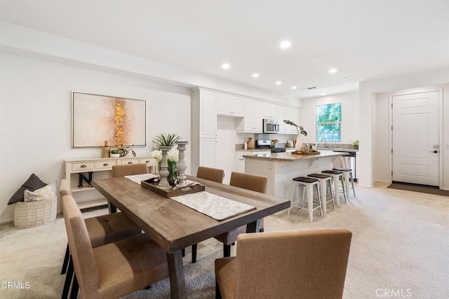 carpeted dining area with sink