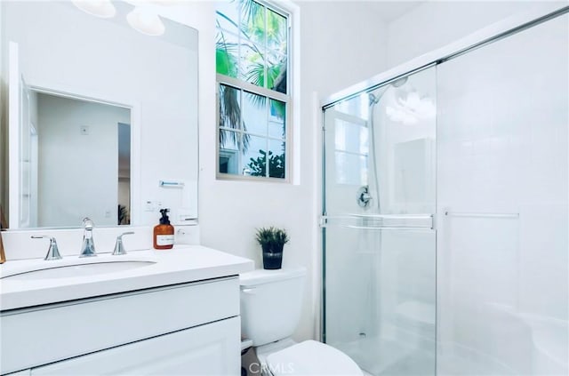 bathroom featuring vanity, toilet, and an enclosed shower