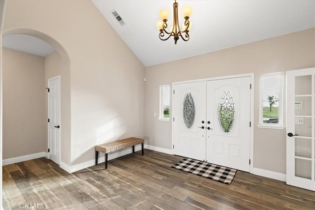 foyer entrance featuring vaulted ceiling, dark hardwood / wood-style flooring, and an inviting chandelier