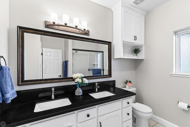 bathroom with toilet, vanity, tile patterned flooring, and a shower